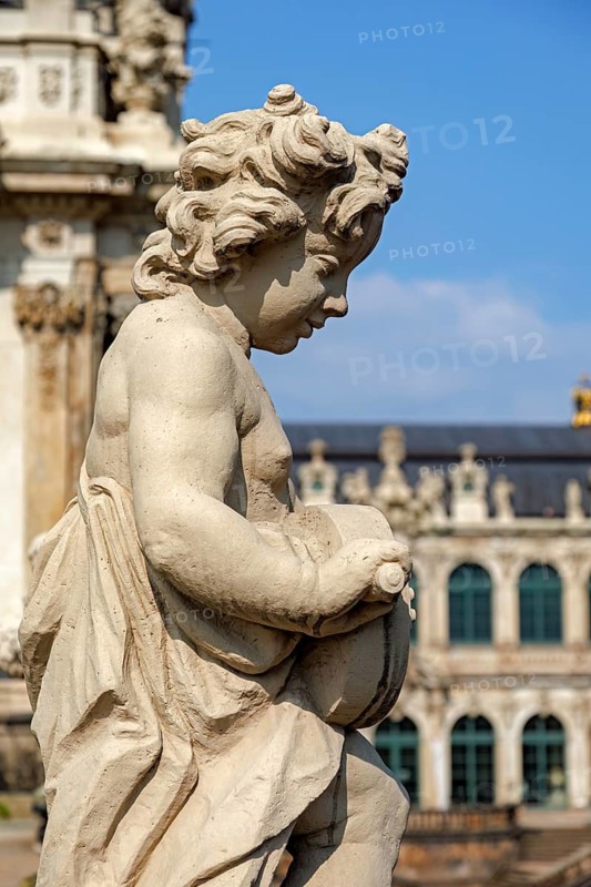 Close-up of an ornate cherub statue in Zwinger Palace, Dresden, Germany. The detailed craftsmanship and classic Baroque architecture highlight the historical significance