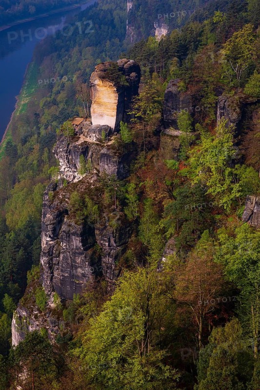 The bright lit Wartturm above the Elbe river seen from the Bastei rocks near the village of Rathen in Saxon Switzerland National Park, Saxony, Germany. On November 22, 2000 the Wartturm was the scene of a spectacular rockfall
