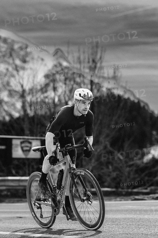 Road bike rider in spring between Lechtal and Tannheimer Tal in front of picturesque scenery of the Alps, Tyrol, Austria