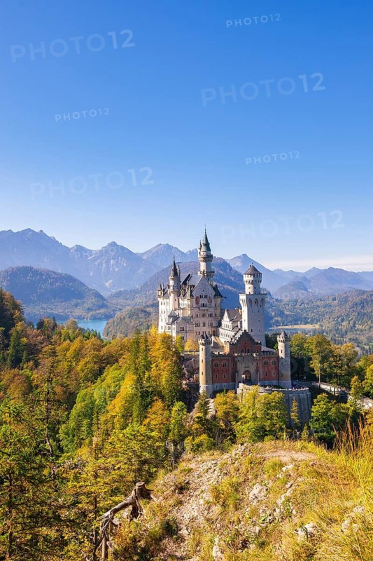 Historic Neuschwanstein Castle surrounded by autumnal forests and an impressive mountain landscape, Schwangau, Ostallgäu, Allgäu, Swabia, Upper Bavaria, Bavaria, Germany