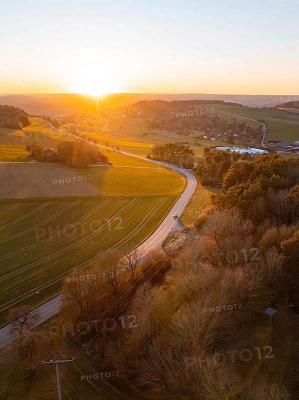 Landscape with winding road at sunset, fields and forests in soft light, Calw, Black Forest, Germany