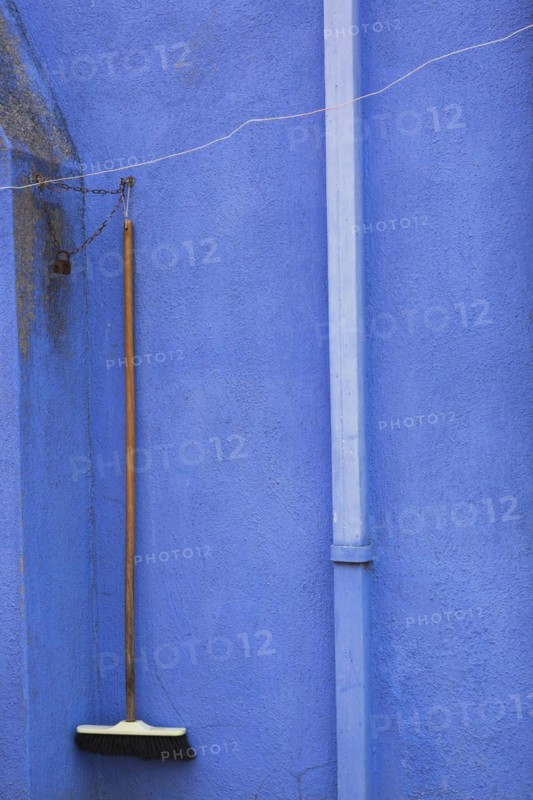 Downspout and broom locked with chain on blue stucco exterior house wall, Burano Island, Venetian Lagoon, Venice, Veneto, Italy