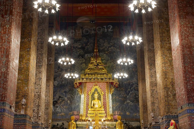 Golden meditating Buddha surrounded by wall paintings with Buddhist teachings and representations of Buddha's disciples, Wat Makut Kasatriyaram Ratchaworavihan, Phra Nakhon District, Old Bangkok, Thailand