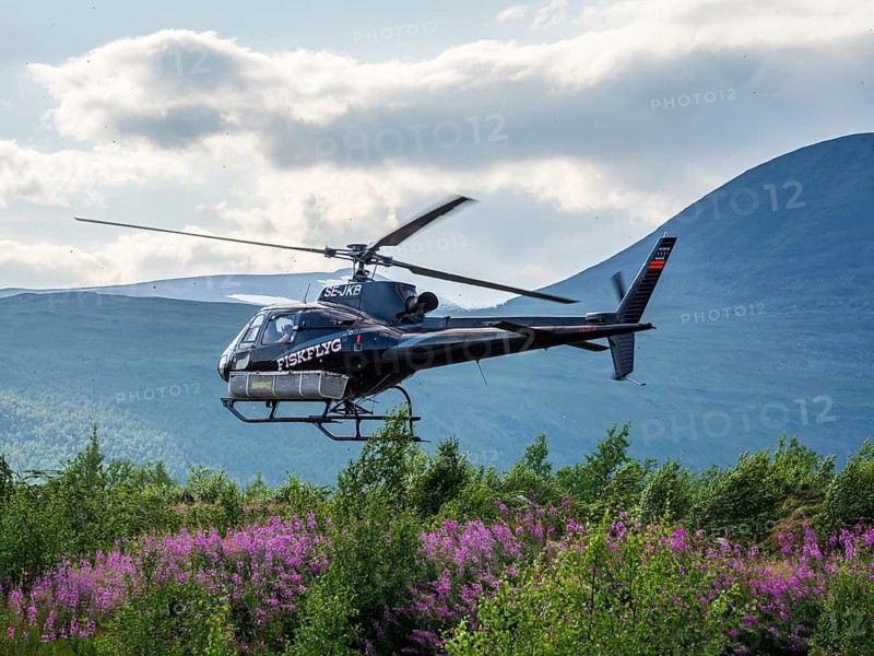Helicopter picking up tourists at a parking lot near Nikkaluokta, flight to Kebnekaise base camp at STF mountain hut, Sweden