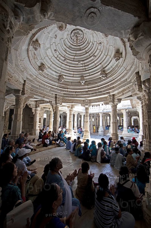 Indian woman praying between the white marble pillars in the Adinath temple in Ranakpur, Jain temple, Rajasthan, India