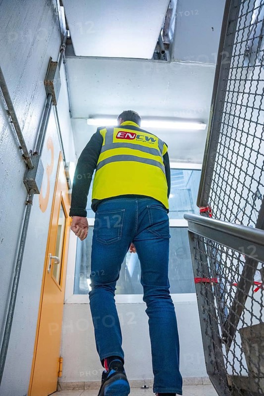 Worker in yellow safety waistcoat walks up the inner staircase, extension of the Calw railway station for the new track of the Hermann Hessebahn, Calw, Black Forest, Germany