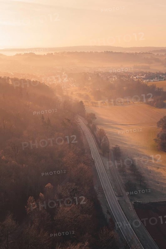 Aerial view of a road through forests and hills in morning fog, Gechingen, Calw district, Germany
