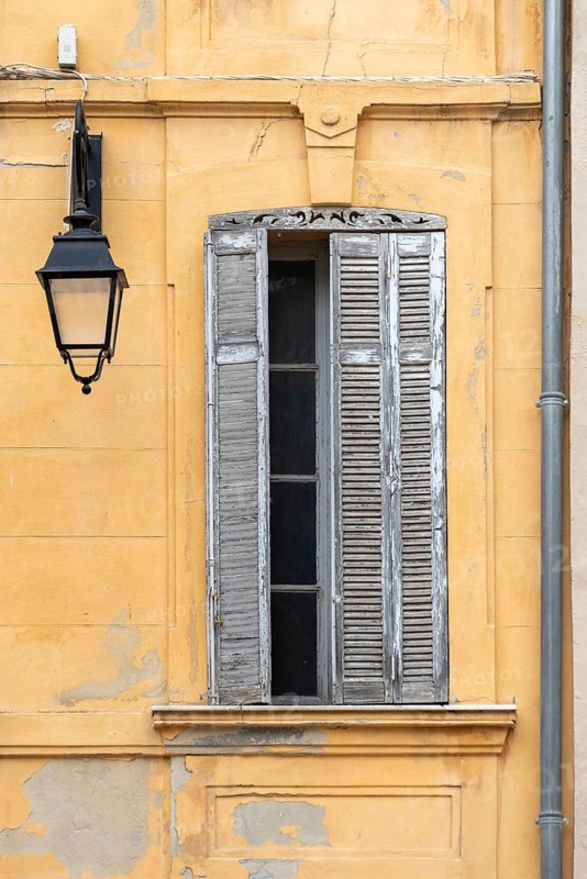 Windows and shutters against a yellow background in the historic centre of Aix-en-Provence, Provence-Alpes-Côte d'Azur, France
