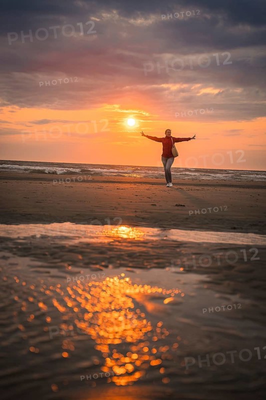 Tourist in red at sunset on the beach, Zandvoort, Netherlands