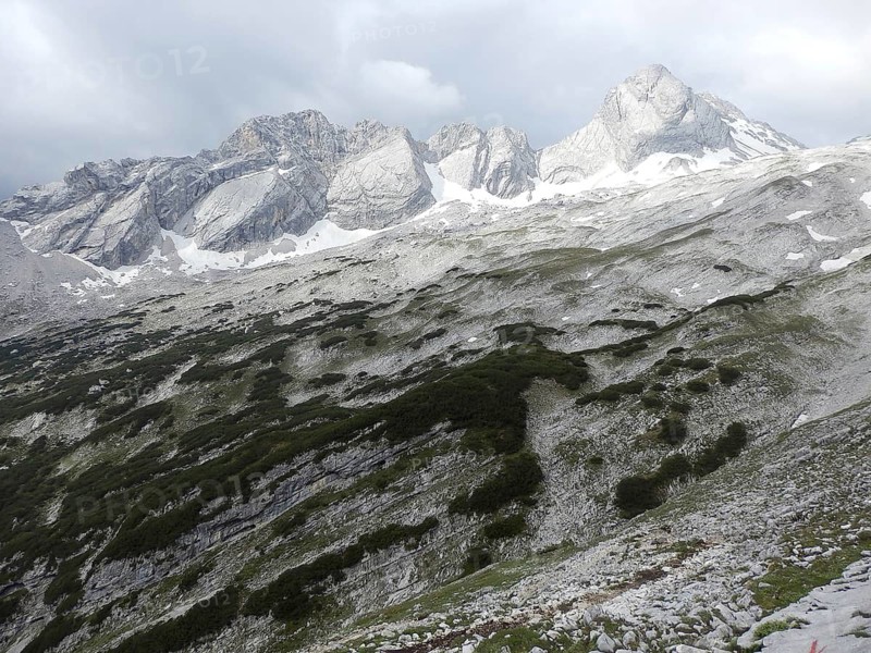 Rocky mountain landscape in the Alps with snow-capped peaks and clouds, hiking through the Reintal valley to the Zugspitze