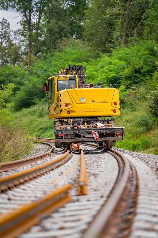 Yellow construction equipment working on railway tracks in the middle of a green landscape, track construction, Hermann Hessebahn, Calw, Black Forest, Germany