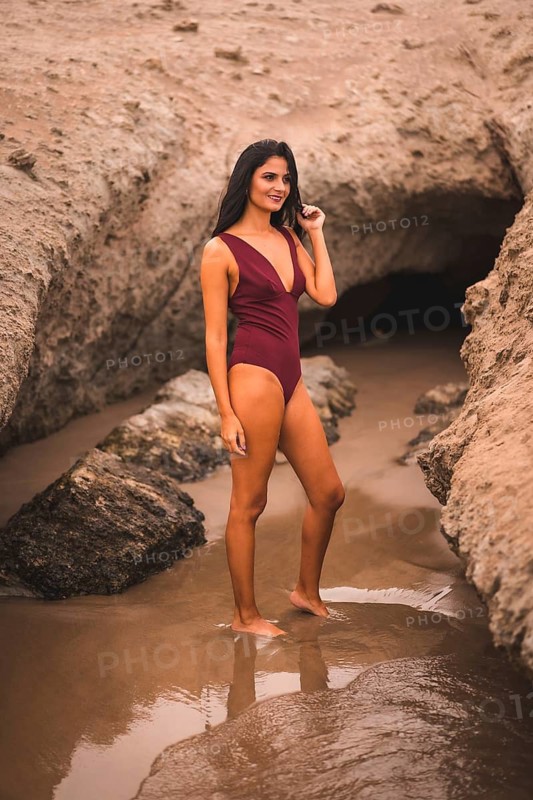 Brunette Caucasian woman with a maroon swimsuit enjoying the summer on the beach of Cabo de Gata, Nijar. Andalucia, Spain