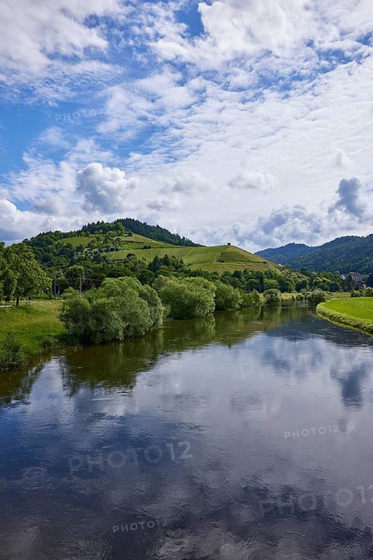 River Kinzig with landscape and blue sky with cumulus clouds in light backlight near Gengenbach, Black Forest, Ortenaukreis, Baden-Württemberg, Germany