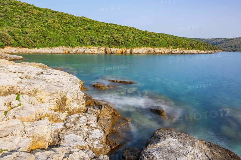 Crystal clear and turquoise water on the beach of Ustrine Bay on a sunny day on the island of Cres, long exposure, Croatia
