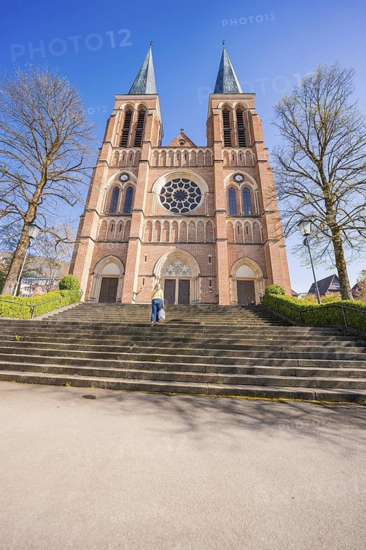 Front view of a large brick church with double towers and stairs, Sacred Heart, Bregenz, Austria