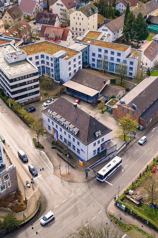 Urban intersection with buildings and a bus passing through the central road junction, VHS Oberes Nagoldtal, Nagold, Germany