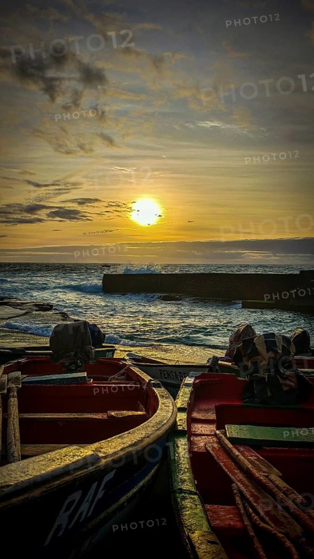 Two boats at sunset with golden sky and waves, romantic harbor scene, Ponta do Sol, Santo Antao, Cabo Verde, Cape Verde, Cape Verde