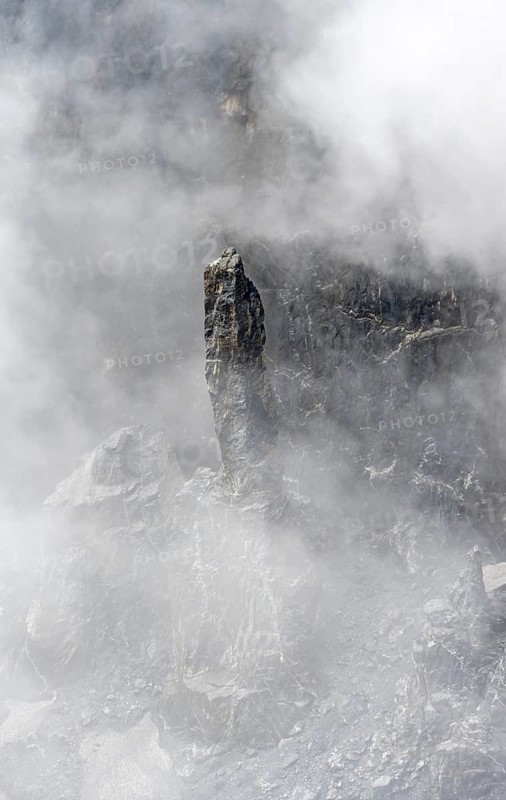 Thin rock needle between steep rock faces, mystical clouds, Bernese Alps, Bernese Oberland, Switzerland