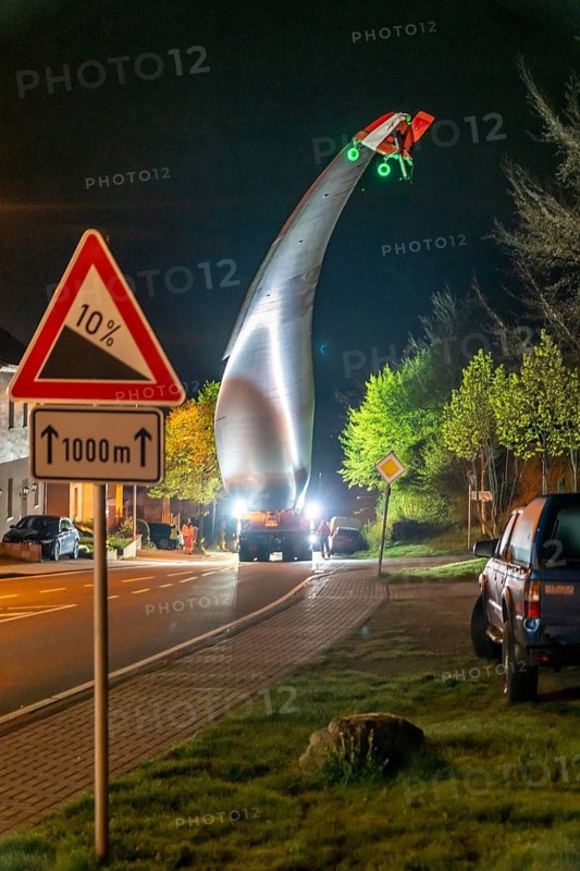 Transport of a 68 metre long, 22 tonne blade of a wind turbine, here in Schwelm, with a self-propelled Blade-Lifter vehicle, over a 40 km long route, over 2 nights, in the Bergisches Land, through towns, villages, over country roads, narrow through roads, to the construction site of the wind turbine near Hagen, North Rhine-Westphalia, Germany