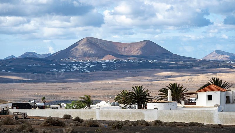 Volcanic landscape with volcanic cone, white houses in the village of Teguise, Lanzarote, Canary Islands, Spain