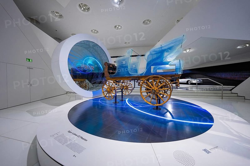 Futuristic depiction of a blue horse-drawn carriage in exhibition, Porsche Museum, Stuttgart, Germany