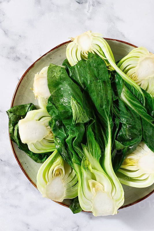 Boiled bok choy, cut on a plate, top view, no people