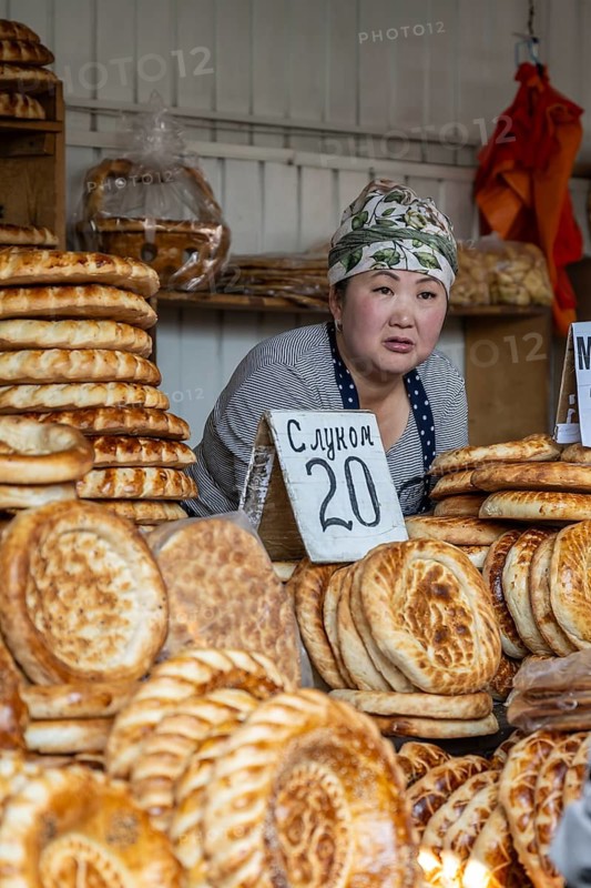 Woman selling bread at a market stall at Osh Bazaar, Bishkek, Kyrgyzstan