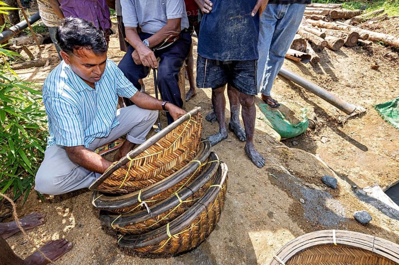 A man works with a basket while others watch, the sapphire and gemstone mines at Ratnapura in Sri Lanka