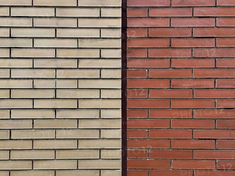 A close-up view of two contrasting brick walls, one beige and one red, highlighting differences in color and texture, creating a visually appealing pattern of symmetry