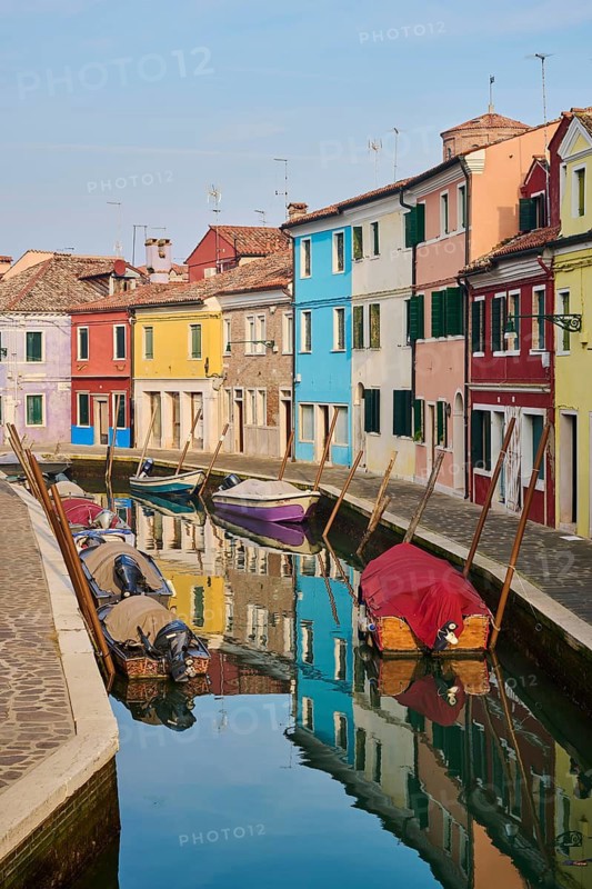 Colorful houses beside the waterway in between 'Fondamenta Pontinello Sinistra' and 'Fondamenta Pontinello Destra' from 'love viewing bridge' with boats lying in the water on the island of Burano, Italy