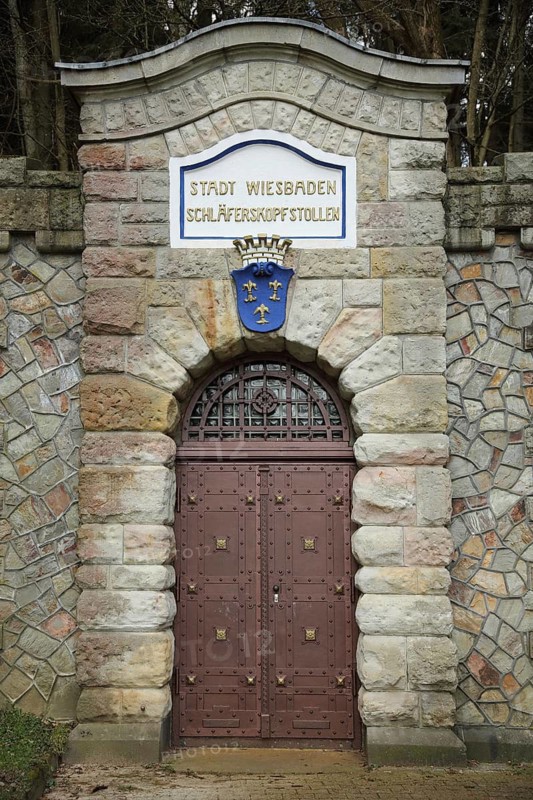 Portal with city coat of arms, door and entrance to the Schläferskopfstollen, inscription, bunker, mine, tunnel, forest edge, Wiesbaden, Taunus, Hesse, Germany