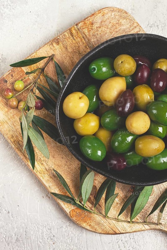 A mixture of olives, varieties of chalkidiki, Verdi giganti and Kalamata, in a bowl, top view, no people