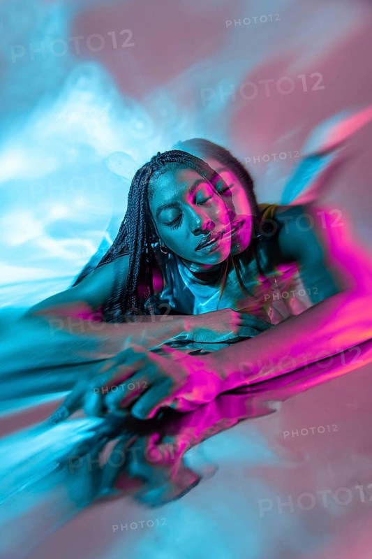 A futuristic African young woman immersed in a vibrant metaverse environment, surrounded by colorful lights and digital effects, embodying innovation and diversity