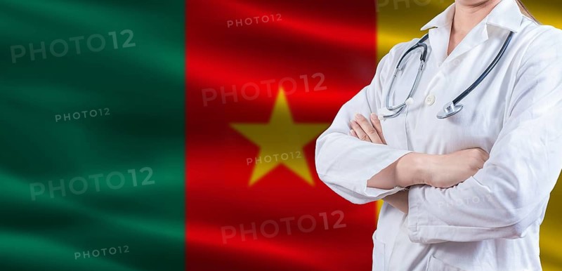 Doctor with crossed arms on Cameroon flag. Cameroonian health and care concept. Female doctor on Cameroon flag