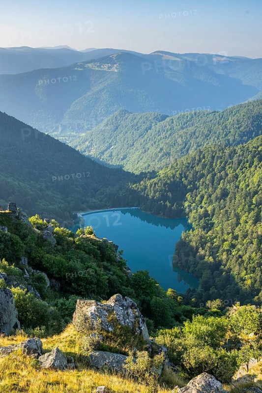 Water reservoir down in the valles on a sunny morning from Mount Hohneck in the Vosges Mountains, France