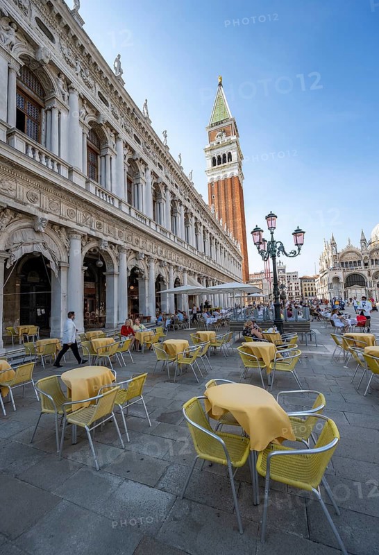 Yellow chairs and tables of a café on St Mark's Square, Campanile, St Mark's Basilica and Doge's Palace, Venice, Veneto, Italy