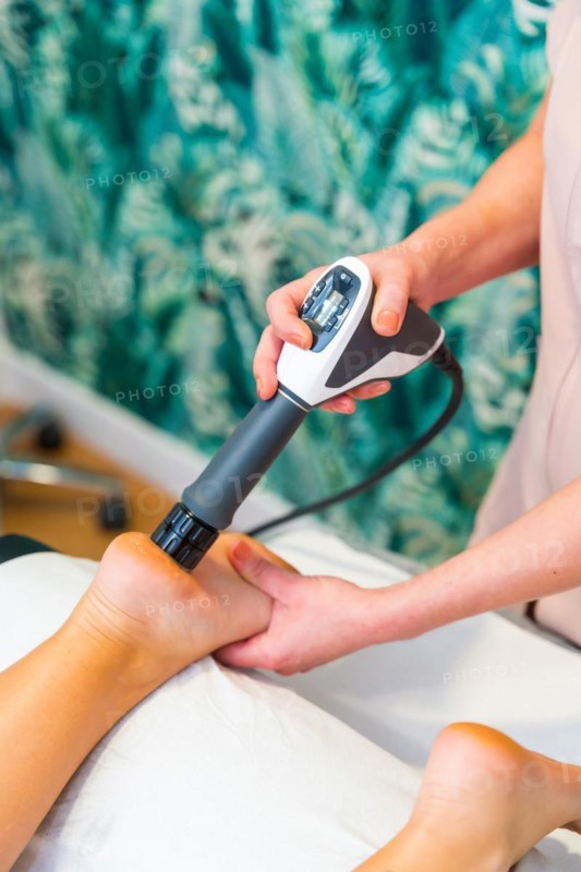 Vertical photo of shock waves therapy to release the pain on patient