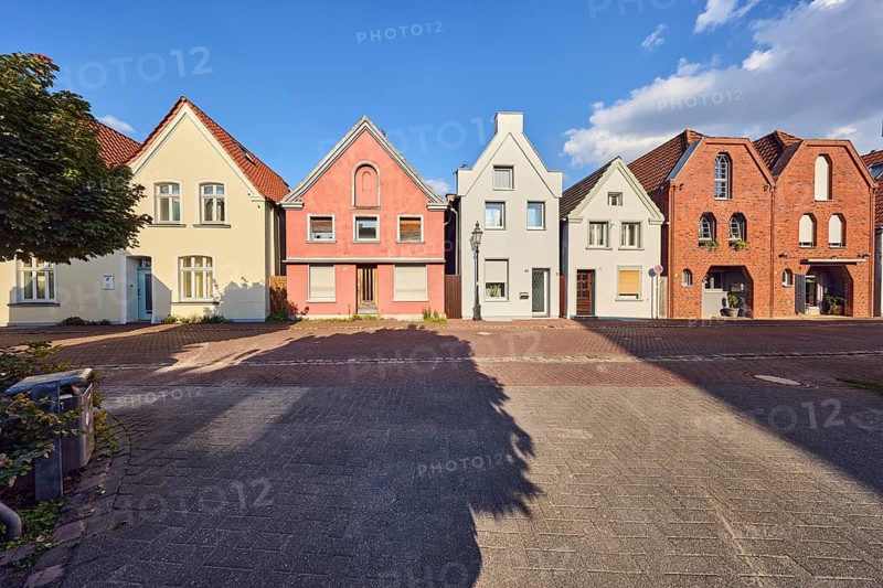 Row of houses, residential building, façade with windows, entrance doors and gables, tree, shadow, blue sky, cumulus clouds, Braugasse confluence in Hermannstraße, Lüdinghausen, Münsterland, Coesfeld district, North Rhine-Westphalia, Germany