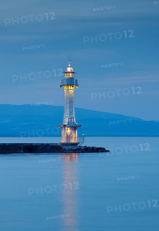 Lighthouse by the harbour wall on the Lake Geneva basin at dusk, Canton Geneva, Switzerland
