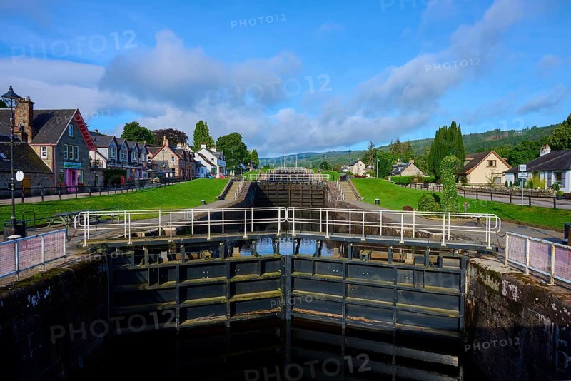 A lock between traditional buildings under a blue sky, Caledonian Canal, Fort Augustus, Loch Ness, Scotland, United Kingdom, United Kingdom