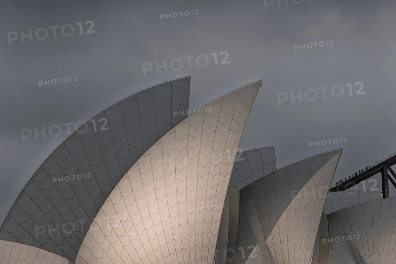Iconic Sidney Opera House prominently against a dramatic overcast sky, showcasing modern architecture bold design and australian elegance