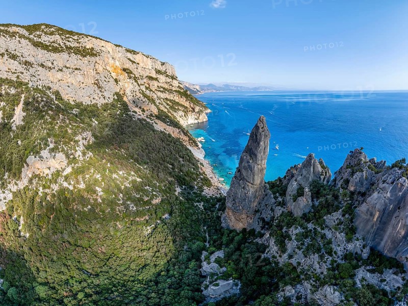 Picturesque rocky coast, cliffs with L'Aguglia pinnacle, blue sea and Cala Goloritzé beach, aerial view, Golfo di Orosei, Baunei, Sardinia, Italy