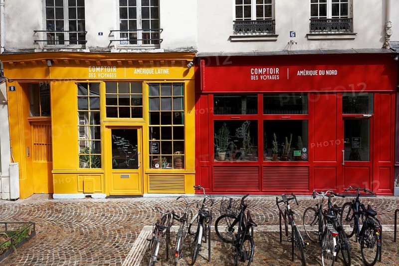Two shop facades in yellow and red next to each other, travel agency for Latin America and for North America, Latin Quarter, Paris, France