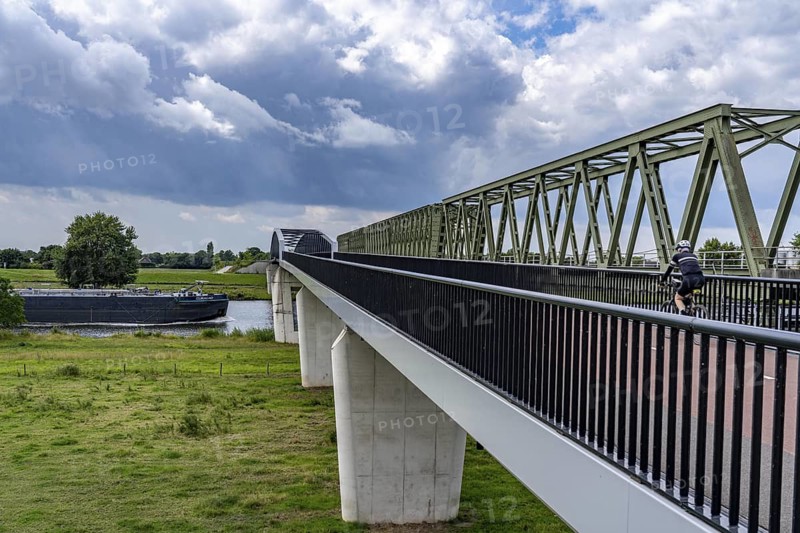 De Massover cycle path bridge, over the Meuse south of Nijmegen, near Cuijk, part of the MaasWaalpad long-distance cycle path, 12 km between Nijmegen and Cuijk, built in 2021, for 15 million euros, Meuse river crossing for cyclists and pedestrians, part of a cycle path network, used by many commuters, next to a railway bridge, Netherlands