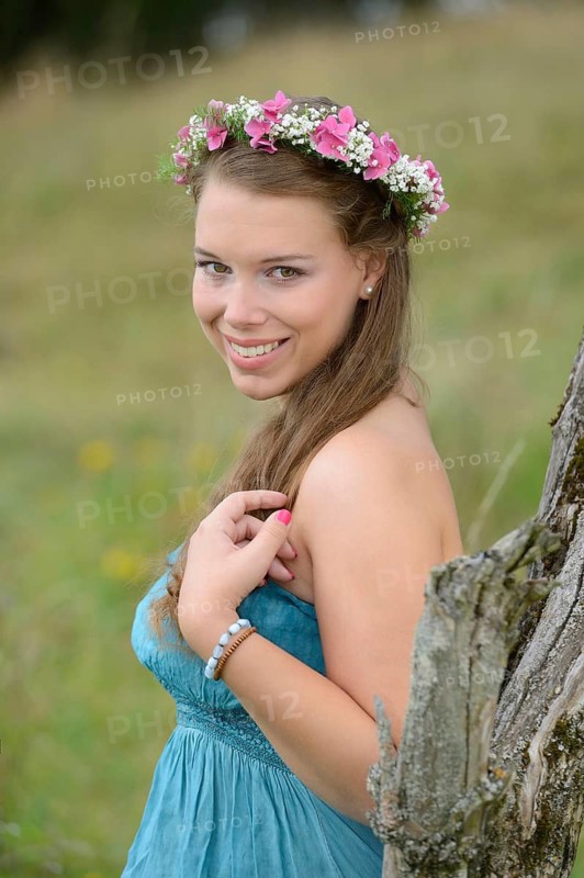 Portrait of a young brunette woman with a floral wreath in her hair outdoors, Germany