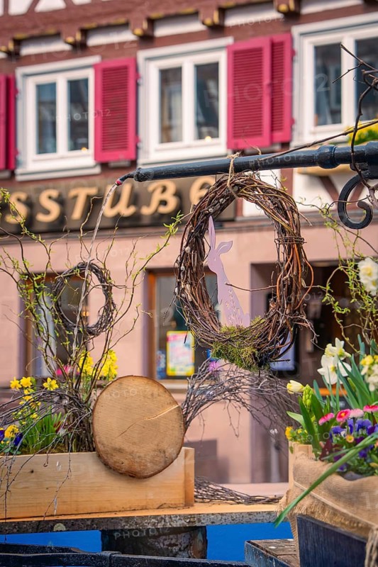 Easter decoration with flowers and wreath on a village square in front of half-timbered houses, Calw, Black Forest, Germany