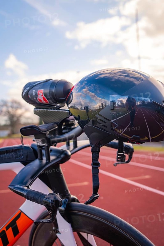 Black bicycle helmet with reflection and camera, parked on a racetrack, triathlon bicycle, Calw, Germany
