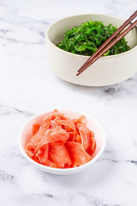 Chuka salad, made from fresh seaweed, with sesame dressing, in a white bowl, with chopsticks and pickled ginger, without people