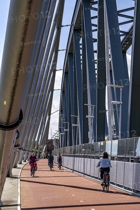 Cycle and pedestrian bridge Snelbinder Brug, over the river Waal near Nijmegen, was added to the existing railway bridge, fast cycle path connection from the city centre of Nijmegen and the new housing estates in the Waalsprong district, Netherlands
