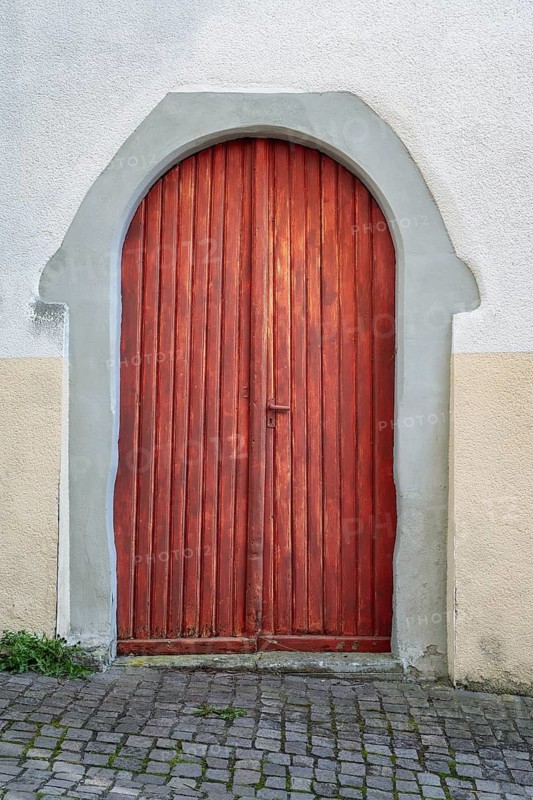 Arc-shaped wooden door surrounded by a grey stone frame in the historic old town of Überlingen am Lake Constance, Bodenseekreis, Baden-Württemberg, Germany